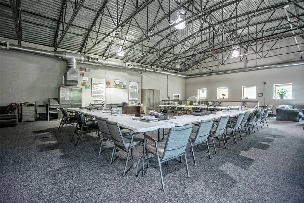 Large group therapy room with tables and chairs