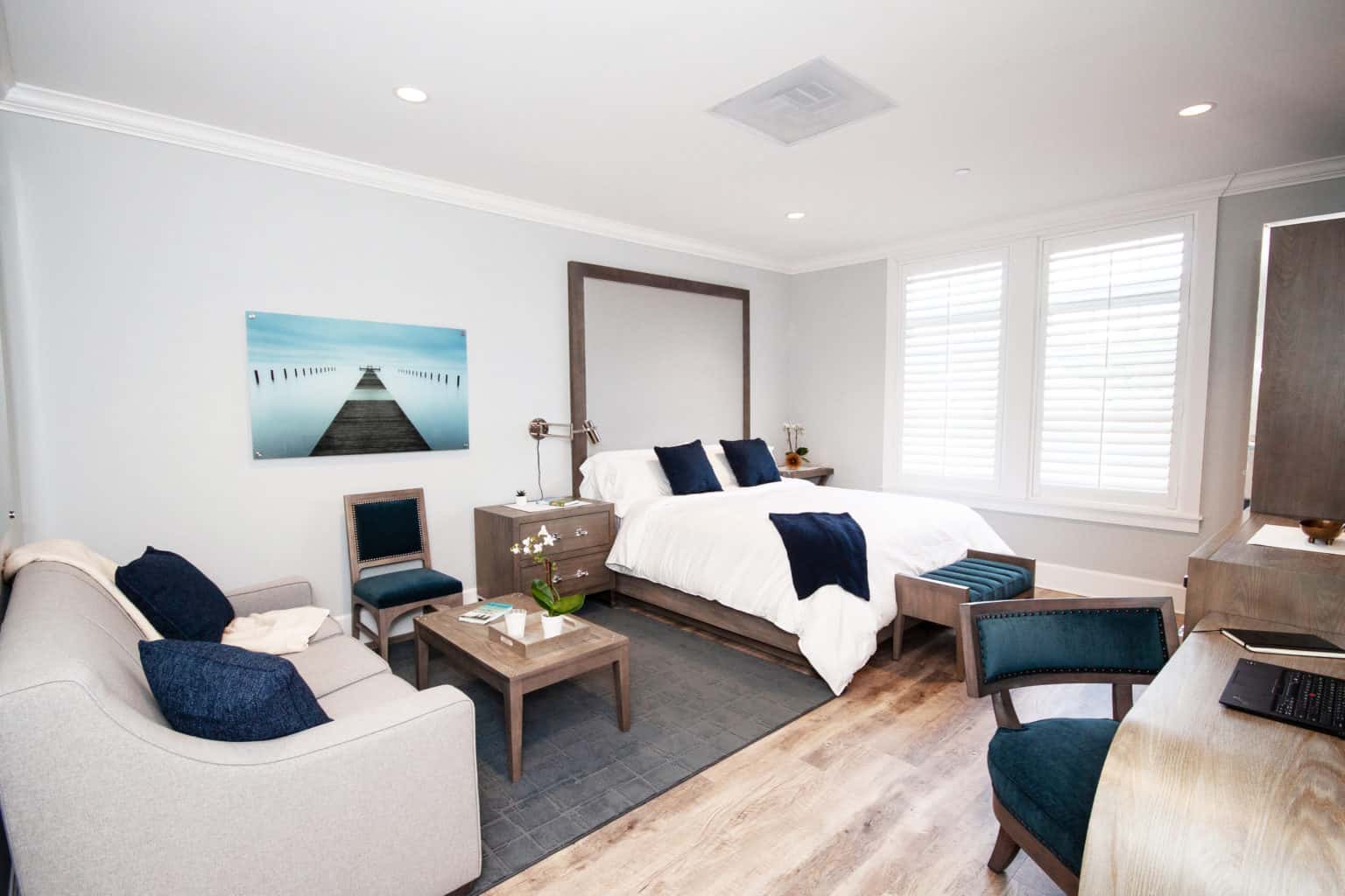 Elegant suite with bed, couch, desk, and soft lighting