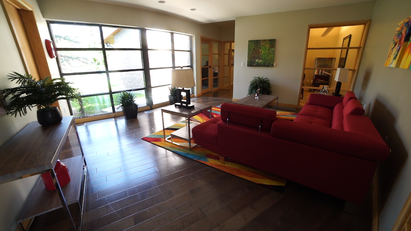 Lounge room with sofas and large windows.
