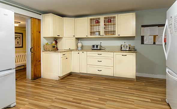 Spacious kitchen with cream cabinets and wood floors