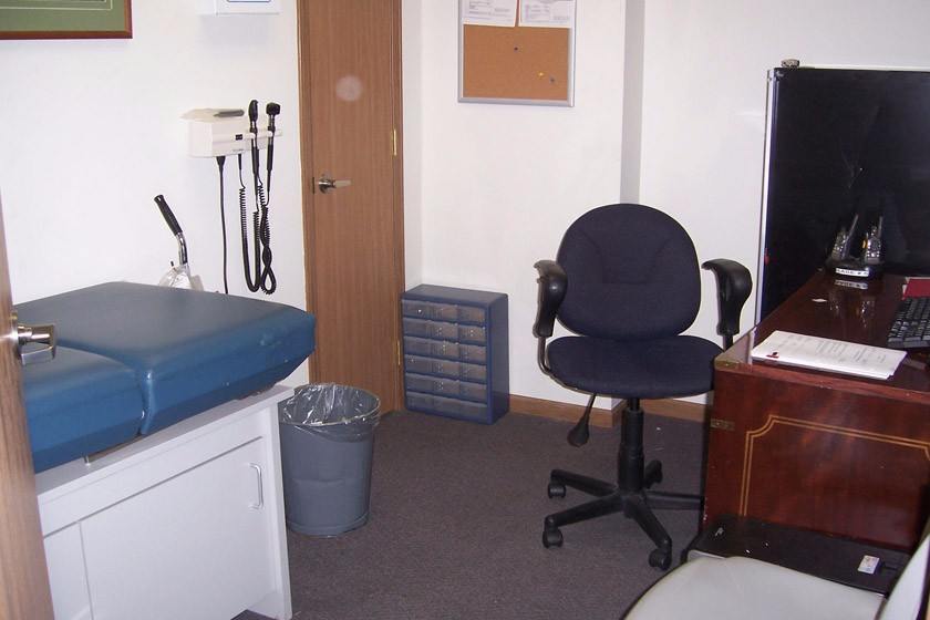 Rehab exam room with exam table and office desk