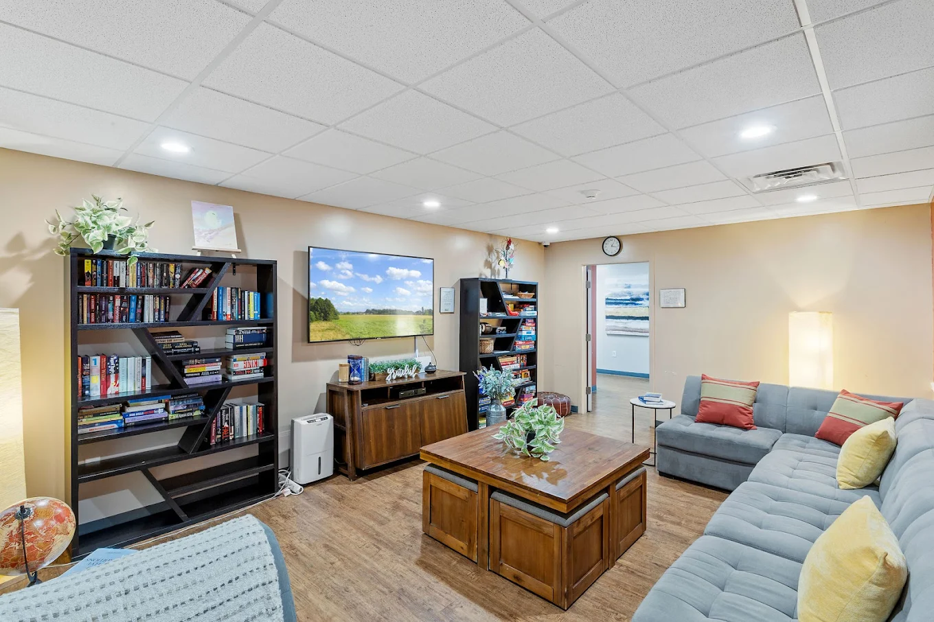 Comfortable seating area with bookshelves, television, and wooden table