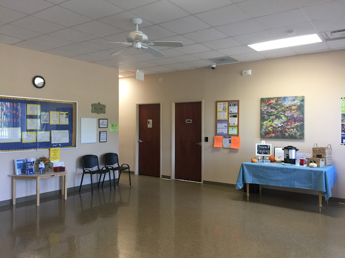 Waiting area with chairs and a refreshment table.
