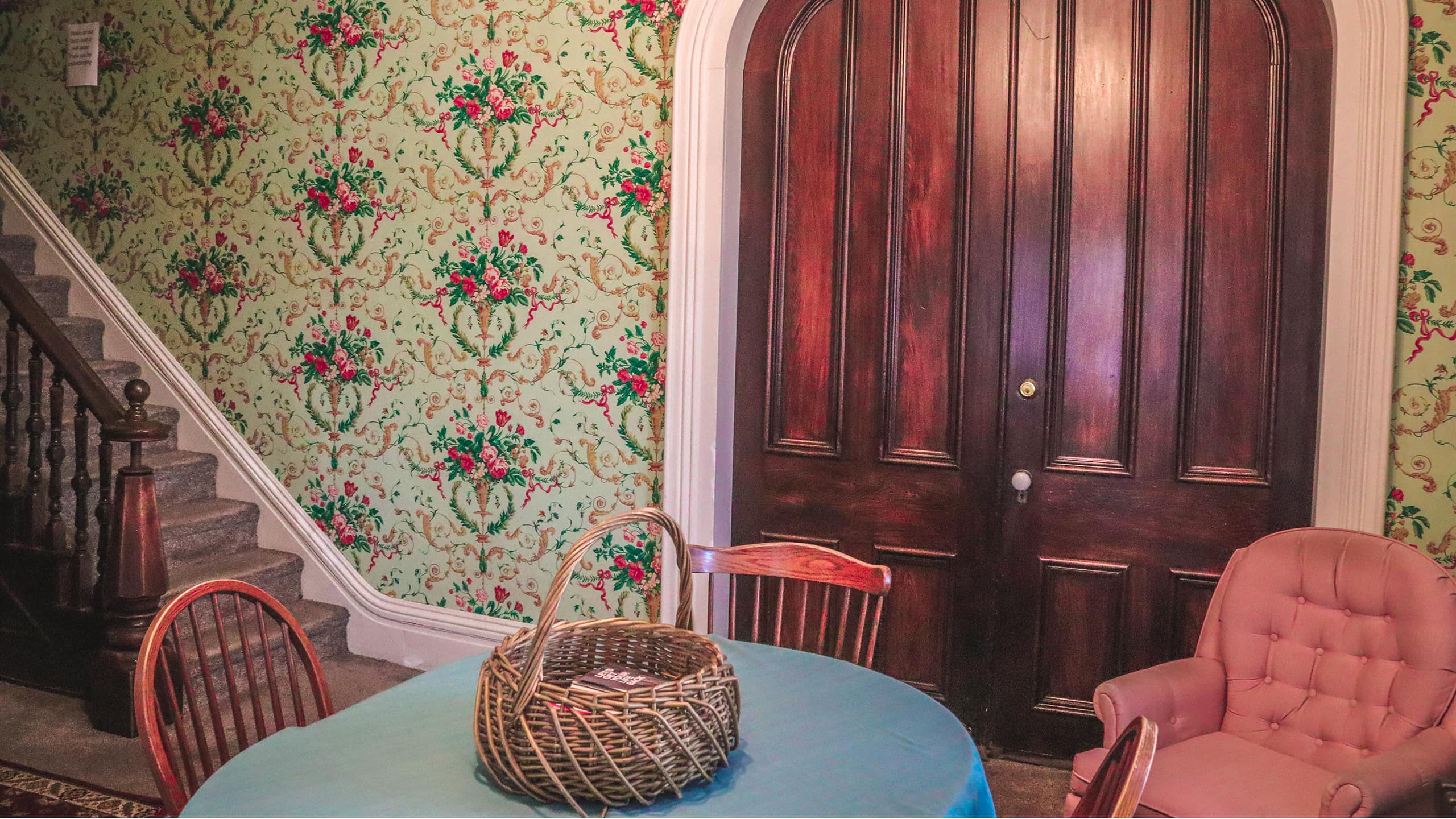 Historic hallway with floral wallpaper and dark wood doors