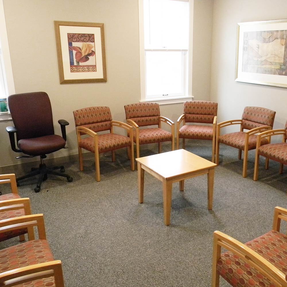 Room with circle of cushioned chairs and small center table