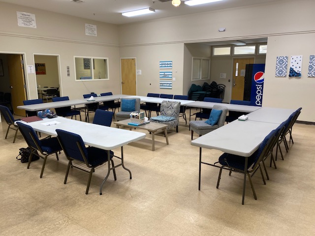 Group therapy room with tables, chairs, and bright lighting