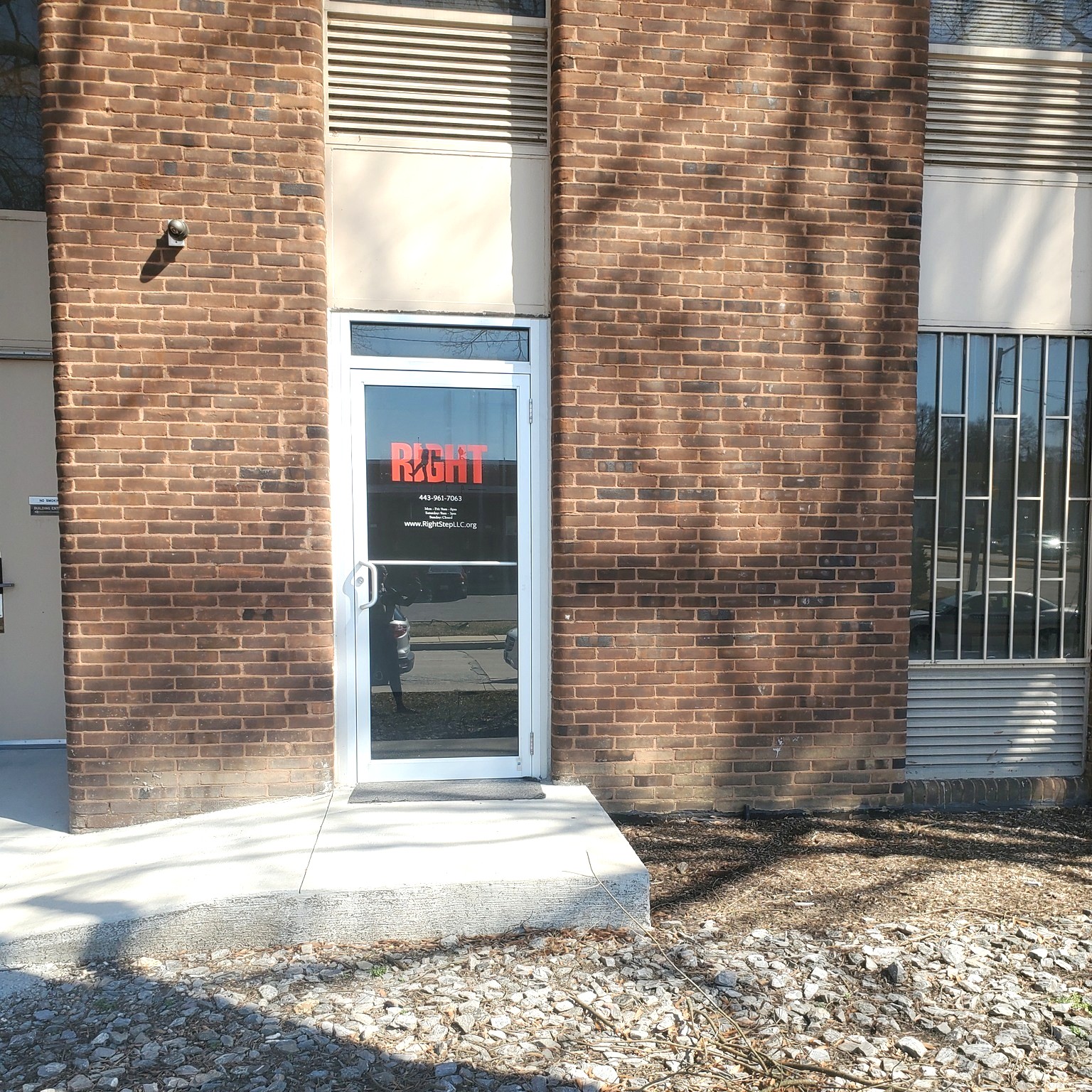 Glass door entrance with Right Step logo on brick building
