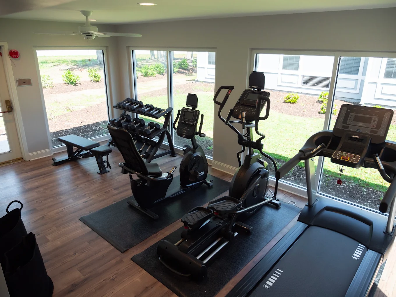 Fitness room with treadmills, exercise bikes, and large windows