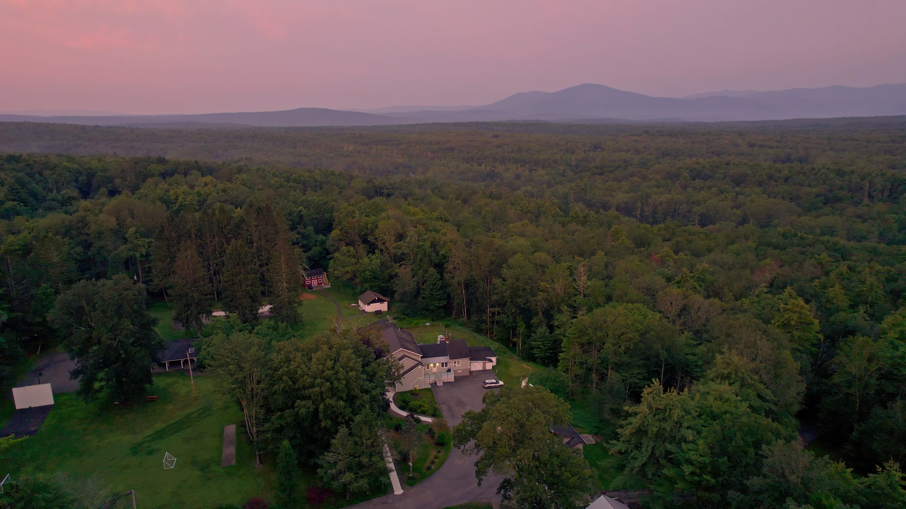 Drone view of campus surrounded by forested mountains.