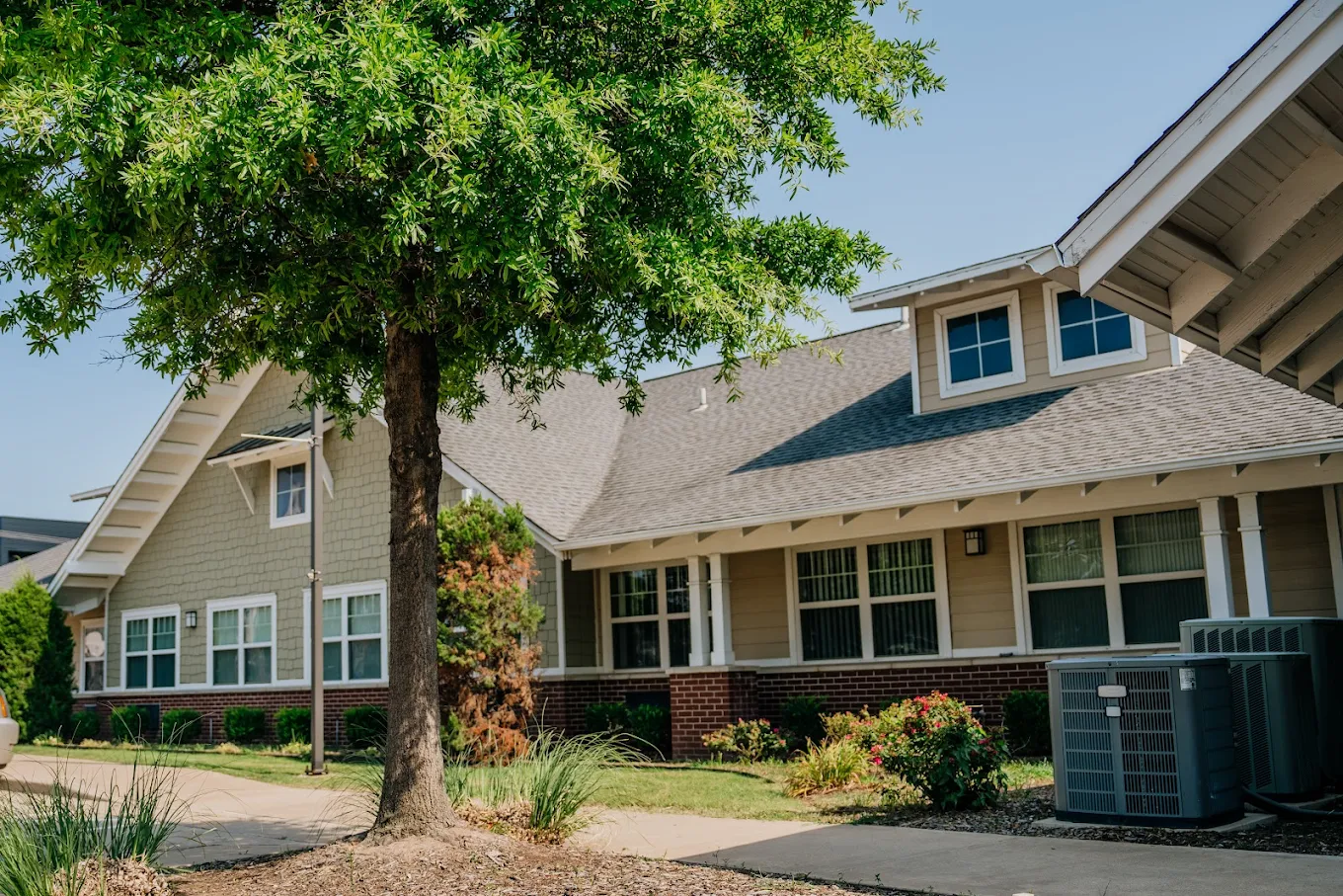 Facility exterior with trees and landscaped walkway.