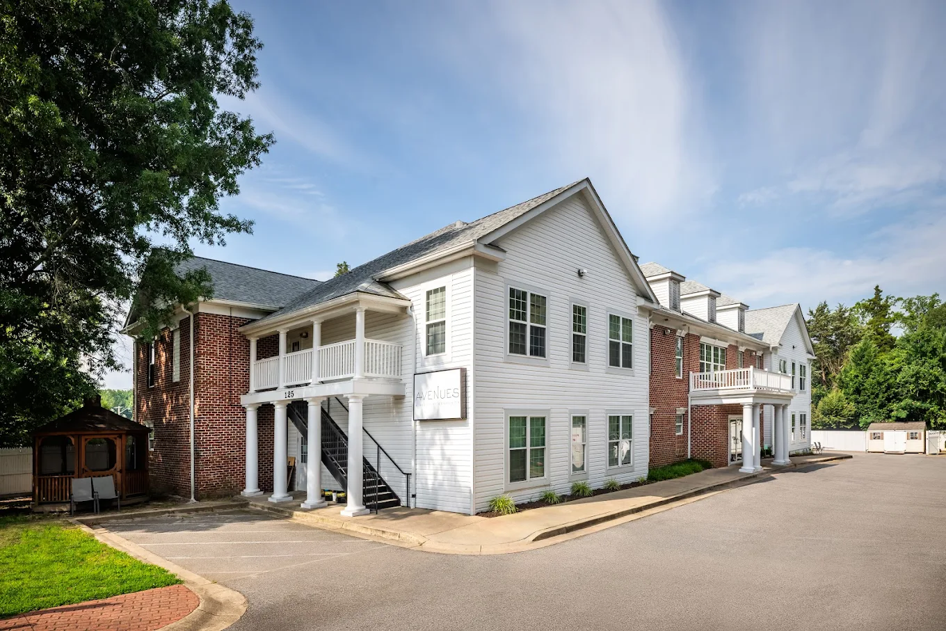 Brick and siding exterior with white columns and balconies
