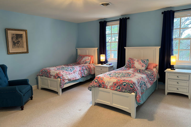 Bright bedroom with pastel twin beds and white furniture