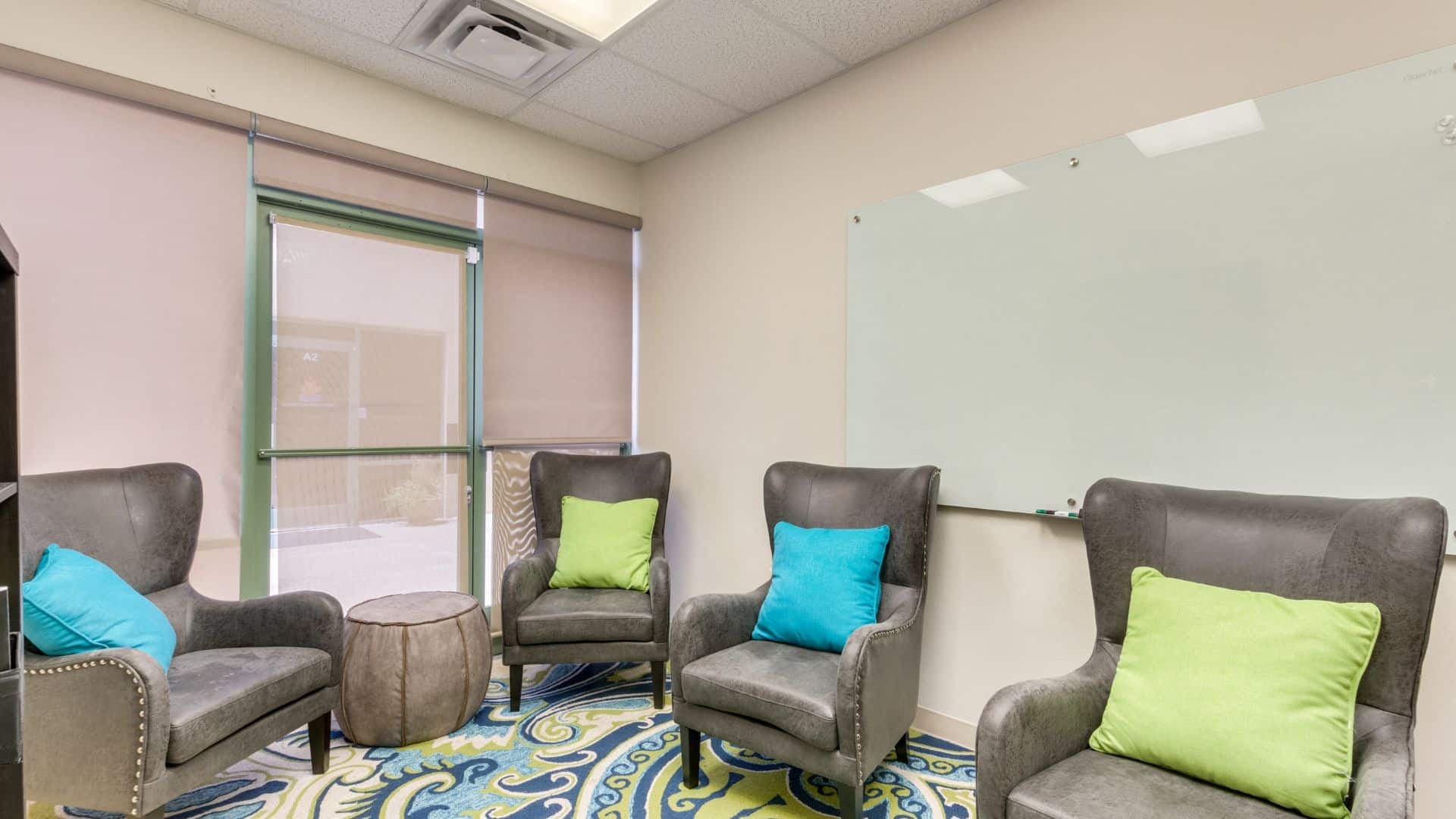 Group therapy room with chairs andlarge window.