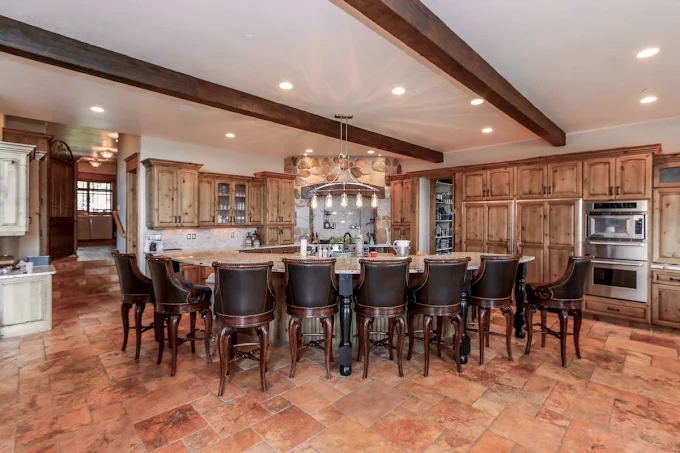 Kitchen with long island, wood cabinets, and 10 chairs