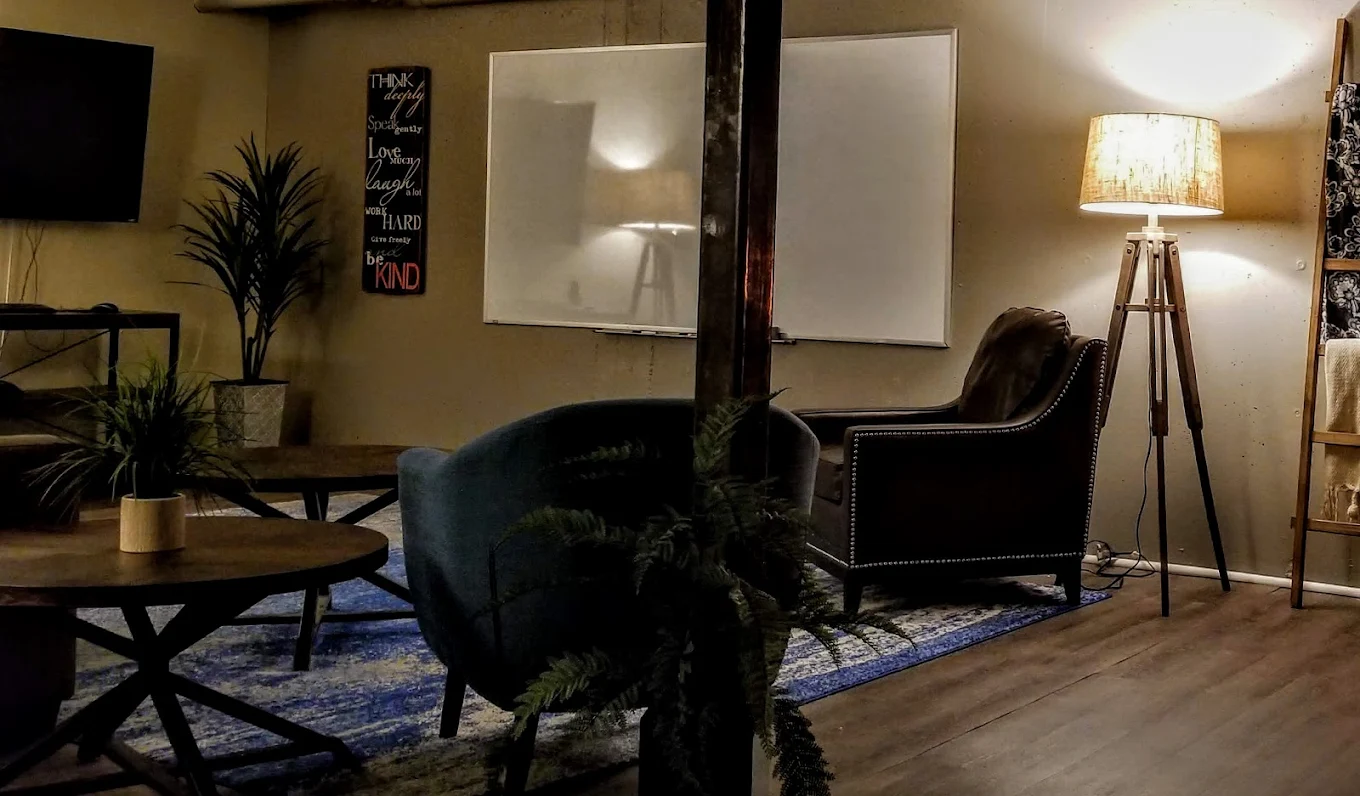 Comfy chairs, whiteboard, and soft lighting setup