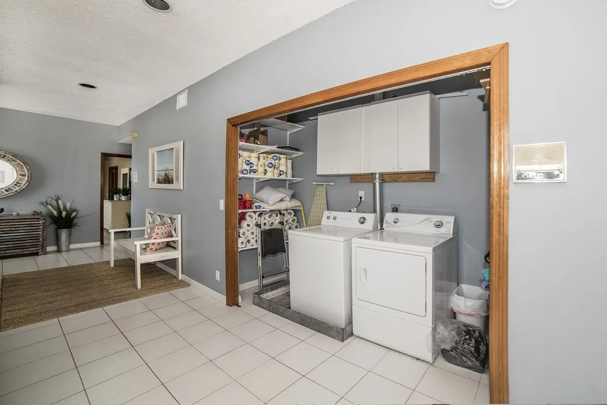 Washer and dryer beside open shelving and seating area