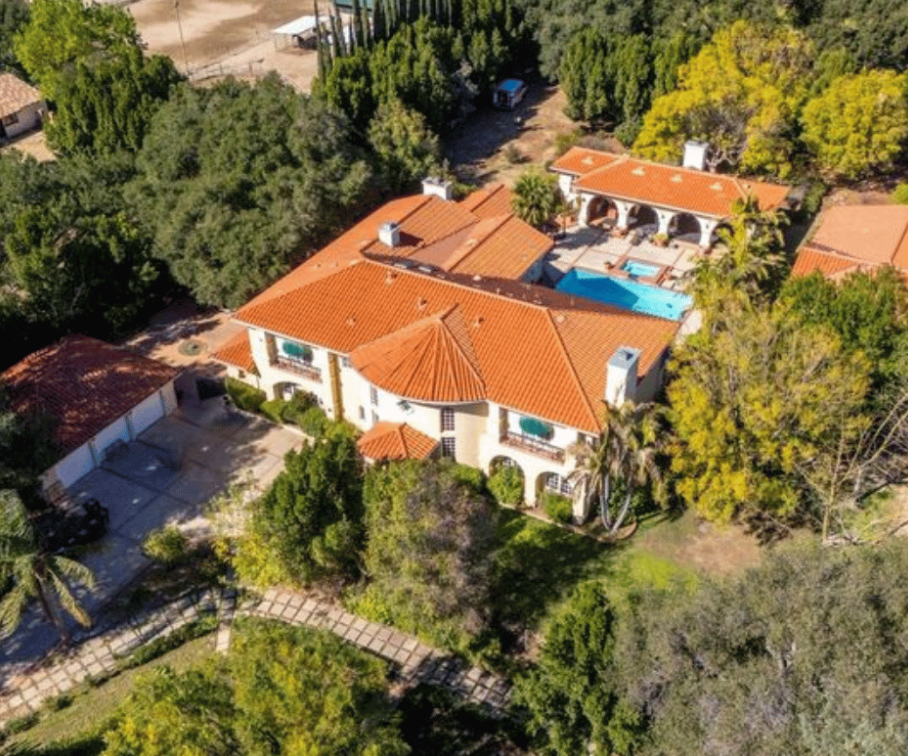 Aerial view of facility surrounded by trees and gardens