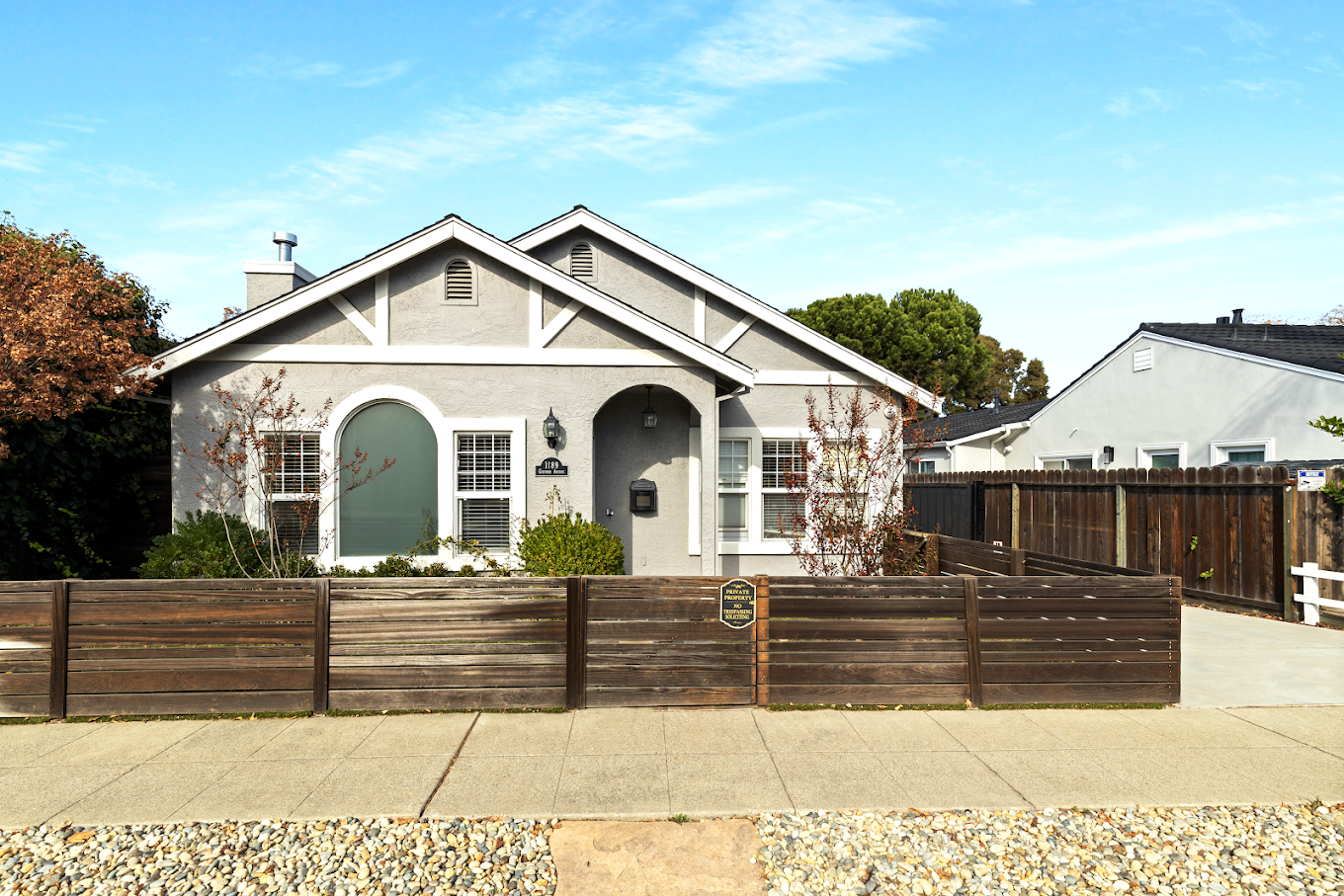 Light gray house with wood fencing and driveway