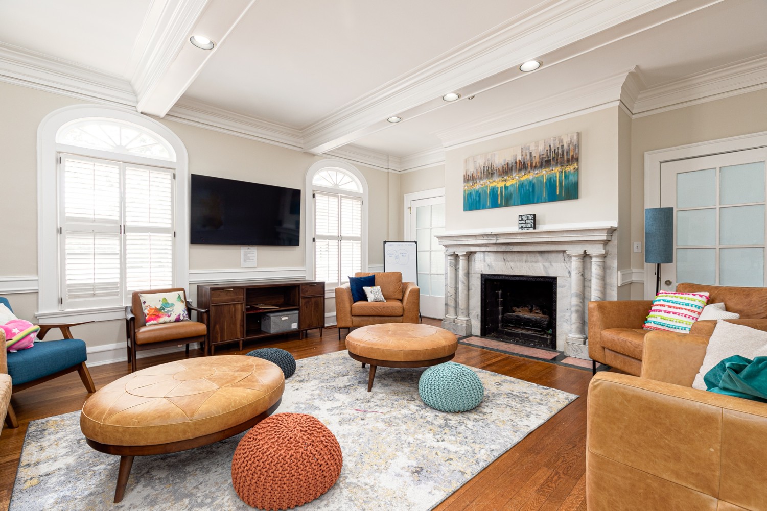 Lounge with round ottomans, chairs, and fireplace