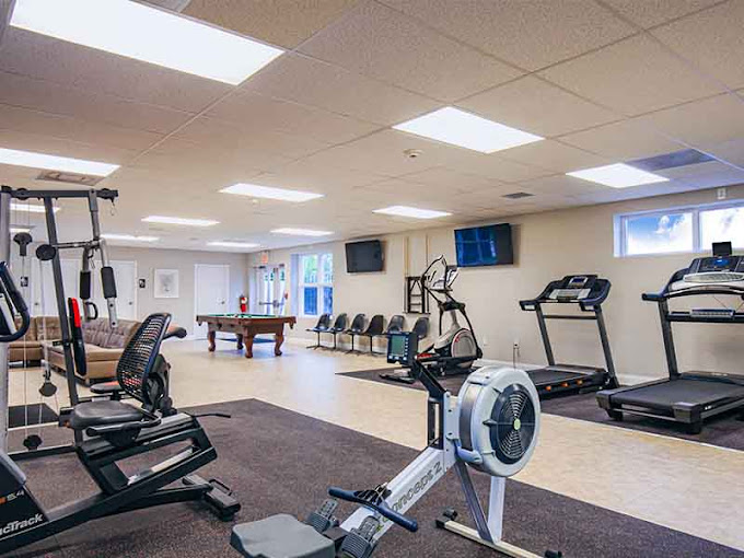 Indoor gym with treadmills, rowing machine, and weight station