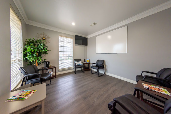 Group meeting room with black chairs and a whiteboard.
