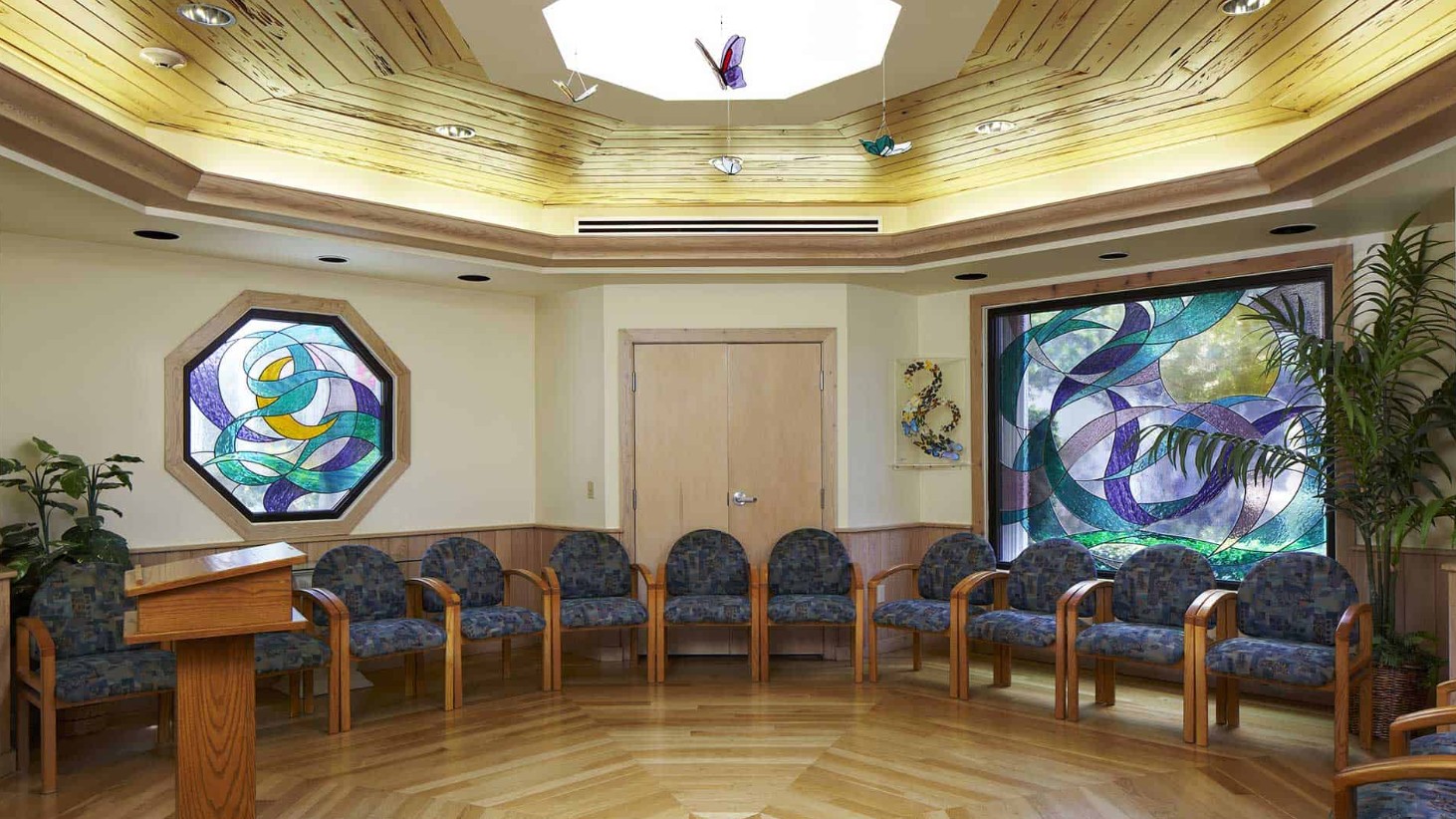 Circular chapel room with chairs and stained glass windows