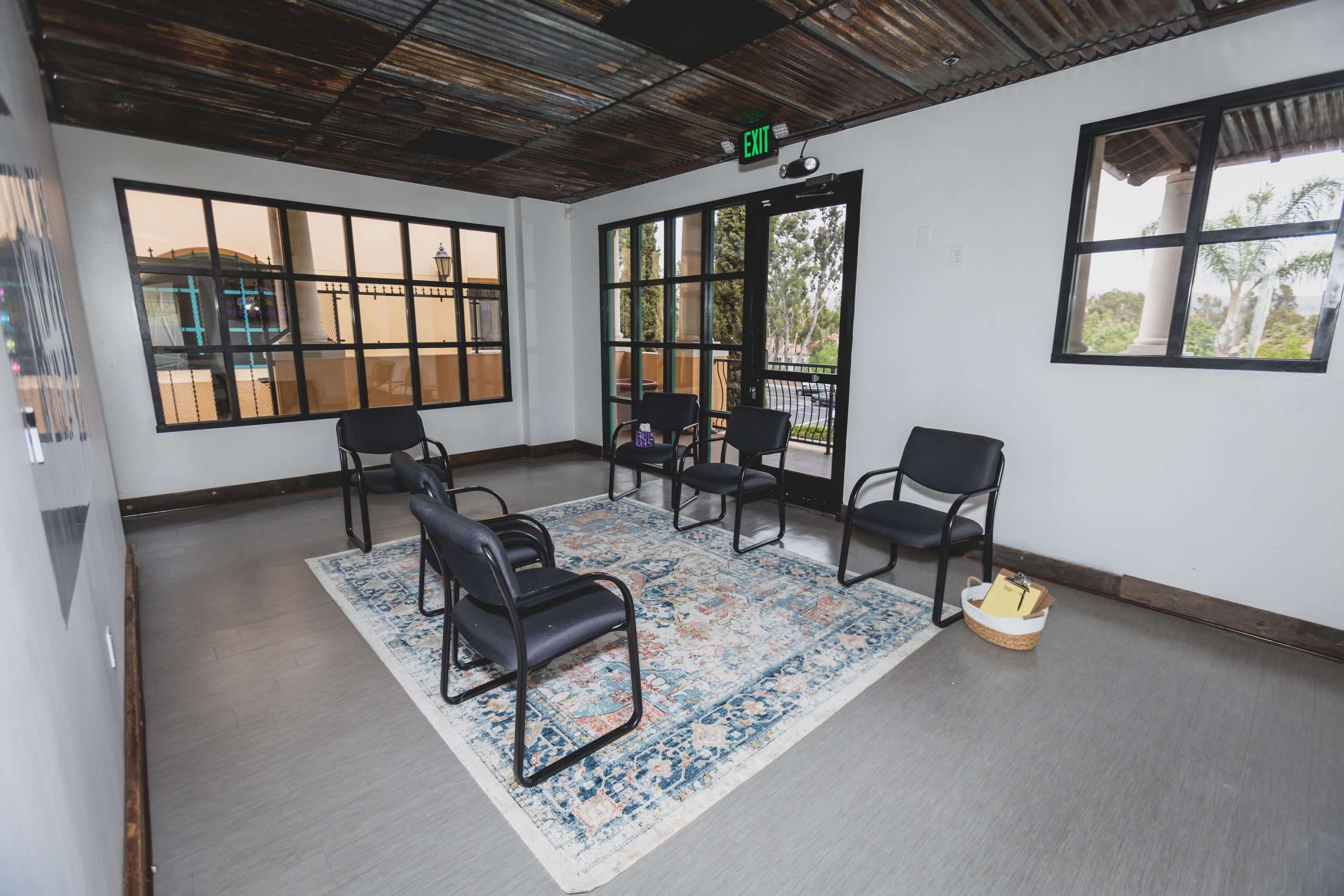 Group therapy space with six chairs in a circle and large windows