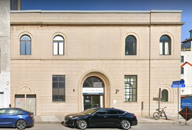Stone building with arched doorway and windows at clinic entrance