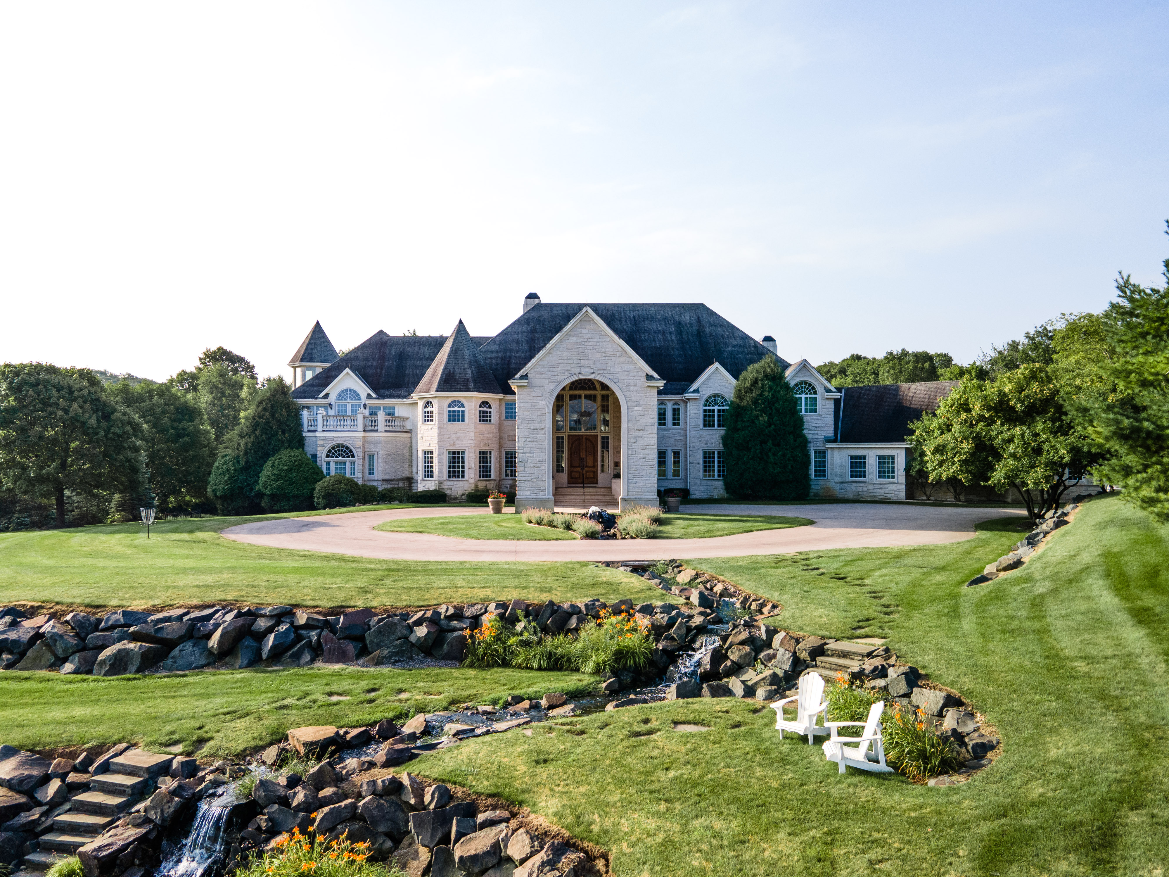 Front of luxury rehab center entrance with greenery.