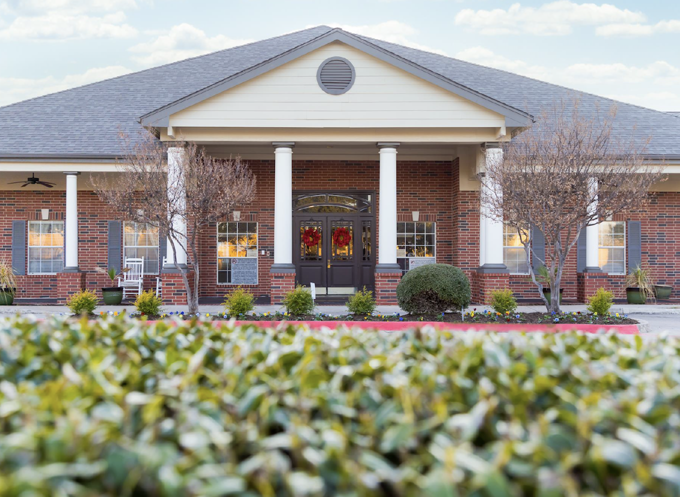 Brick rehab center with columns and wreath-decorated doors