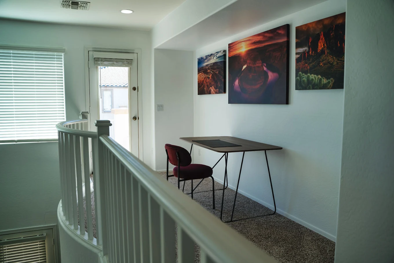 Small desk and chair in upstairs hallway with wall art