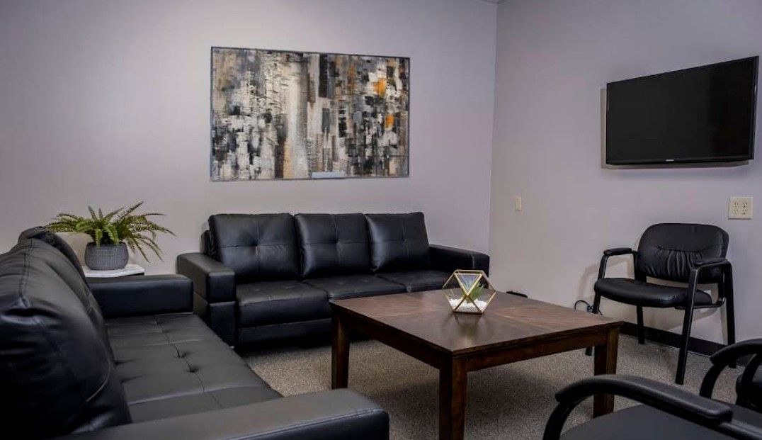 Group room with sofas, chairs, and wall-mounted TV