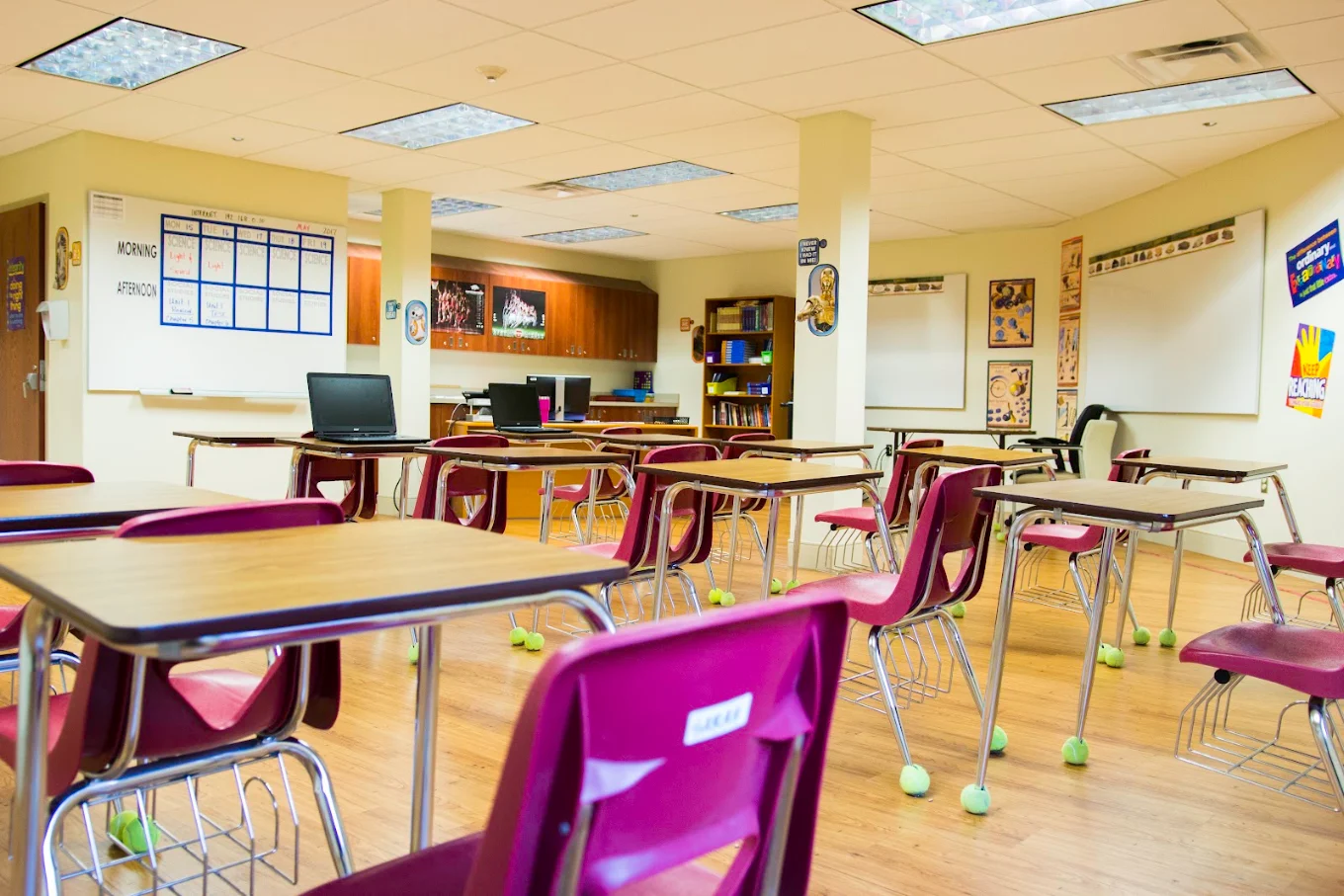 Classroom with individual desks, computers, and whiteboards.