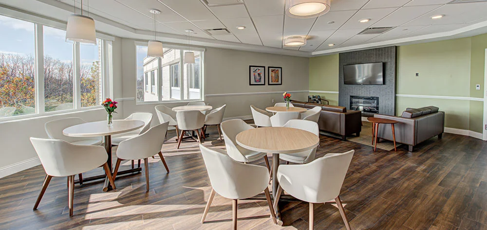 Bright dining area with round tables and white chairs
