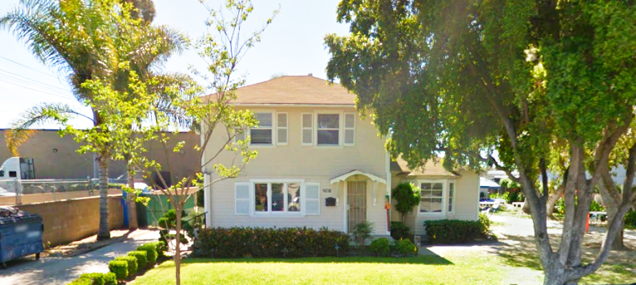 Front view of Little House Inc. building with sign and garden.