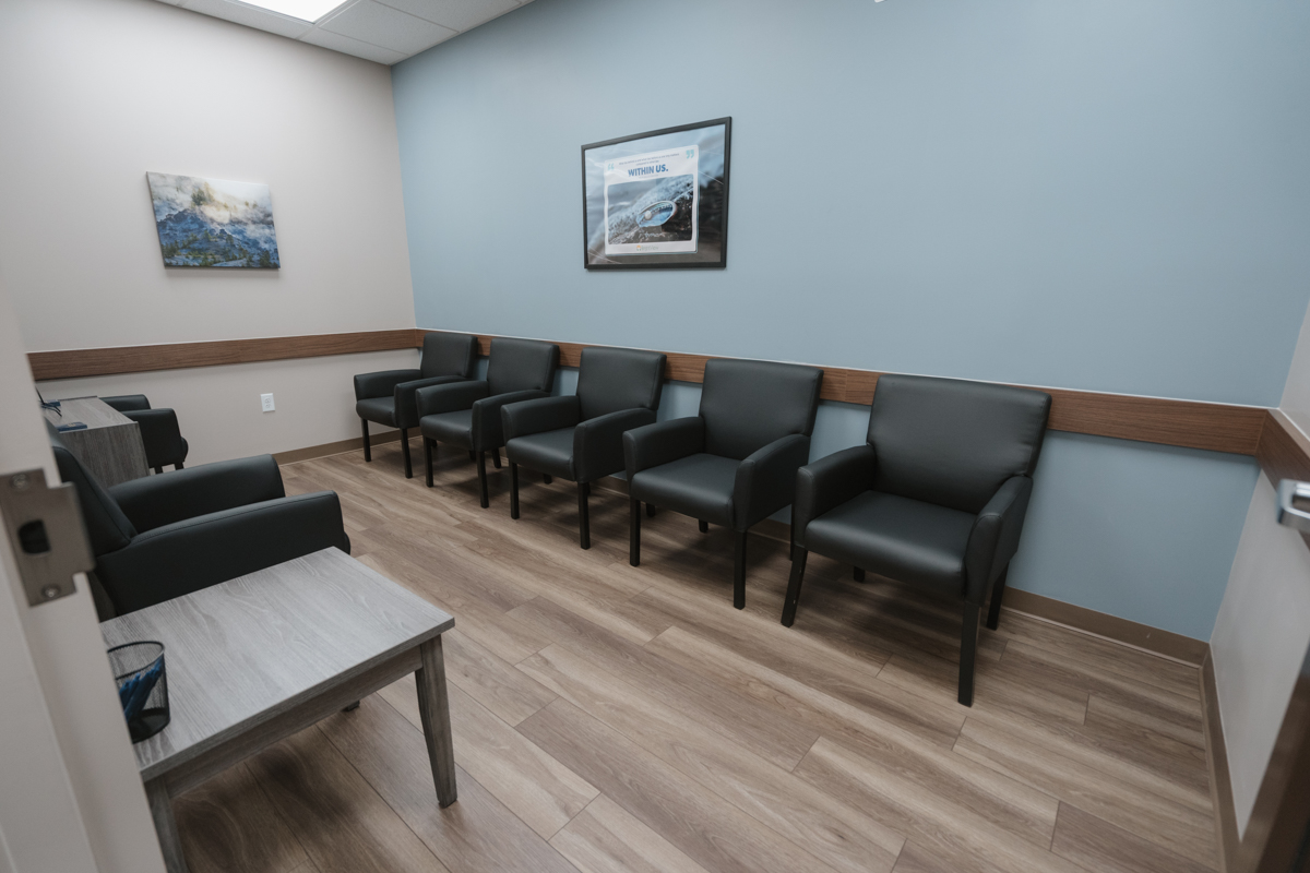 Dosing room with black chairs arranged along blue wall