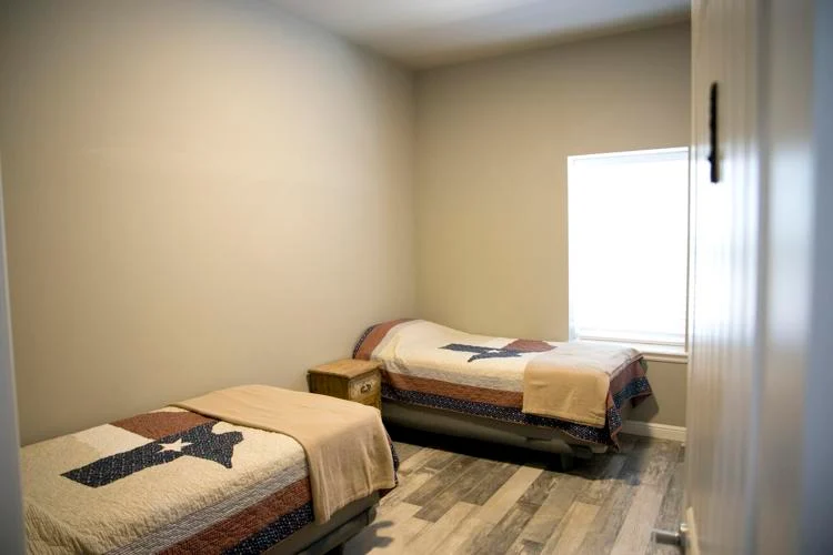 Two single beds in simple room with window