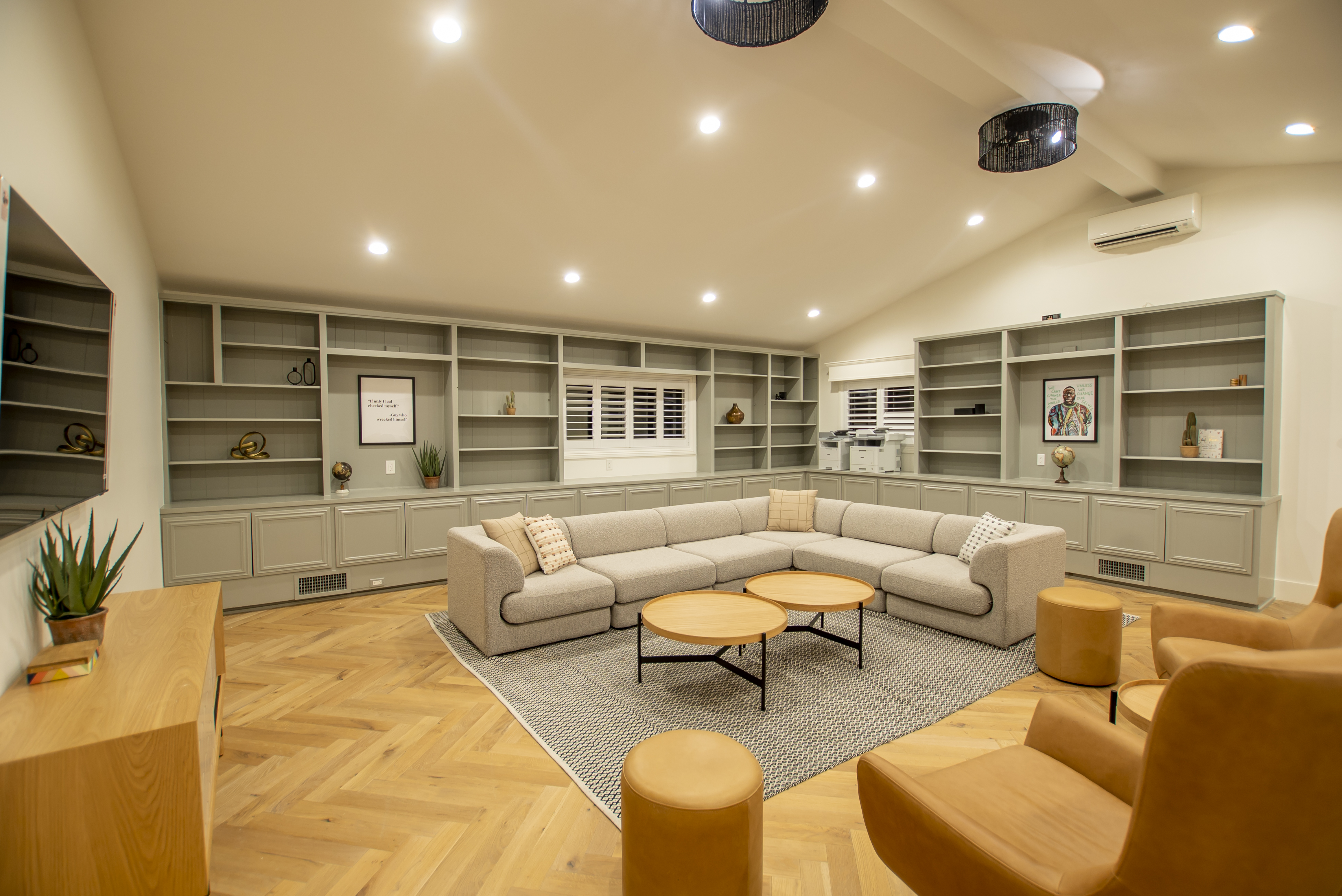 A spacious lounge with built-in shelves and a large sectional sofa.