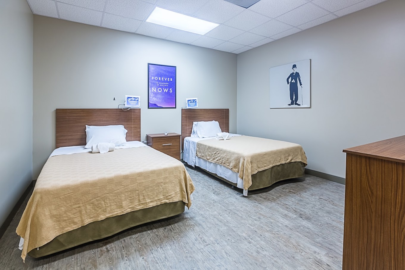 Bedroom with two twin beds, wooden headboards, and wall art.