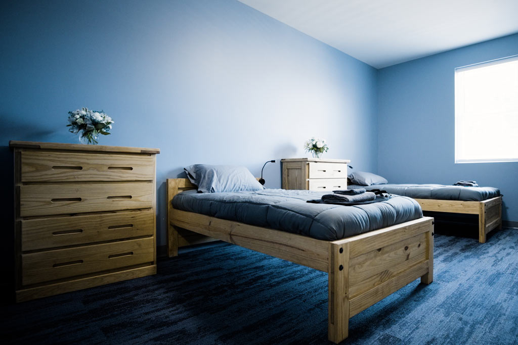 Two single beds with dressers in a bright, clean bedroom