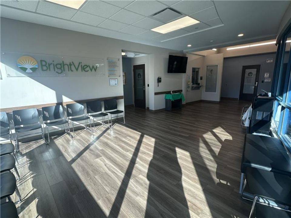 Bright waiting area with rows of chairs and large windows