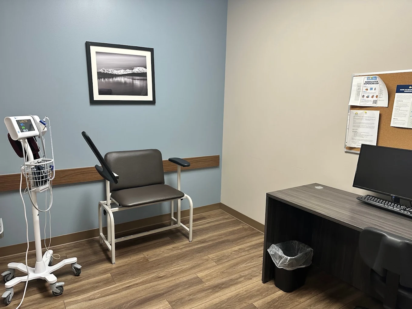 Medical room with patient chair, monitor, and desk