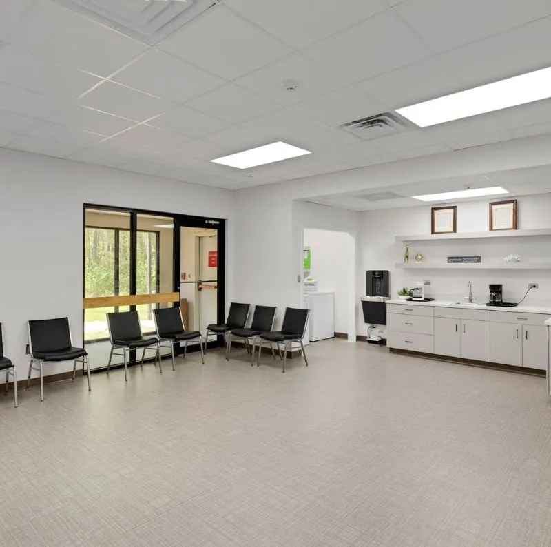 Waiting room with chairs and self-serve coffee area