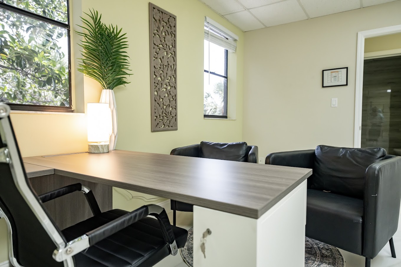 Desk with chairs and decor in a sunlit office space