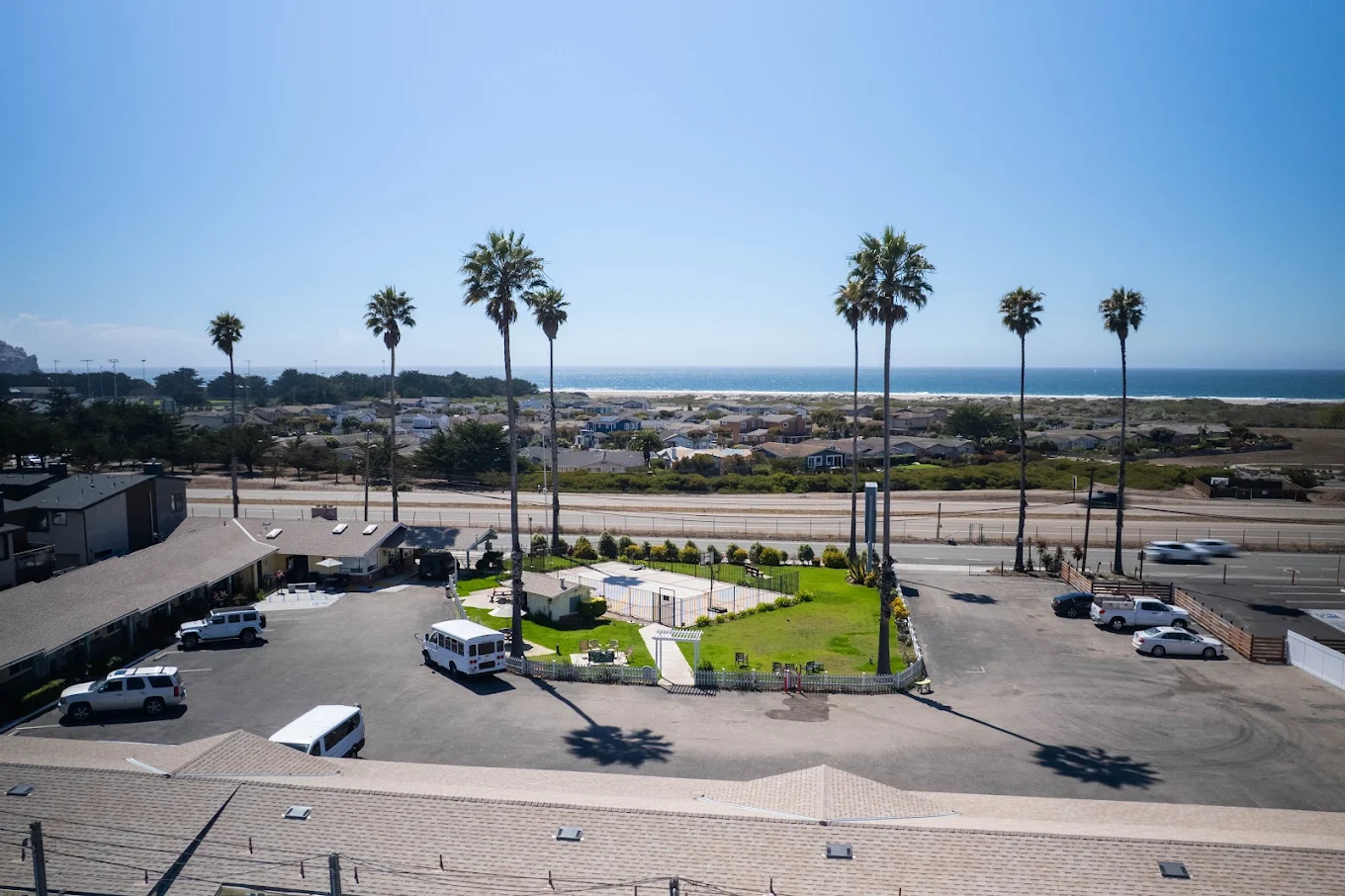 Aerial view of parking area with palm trees and ocean in distance