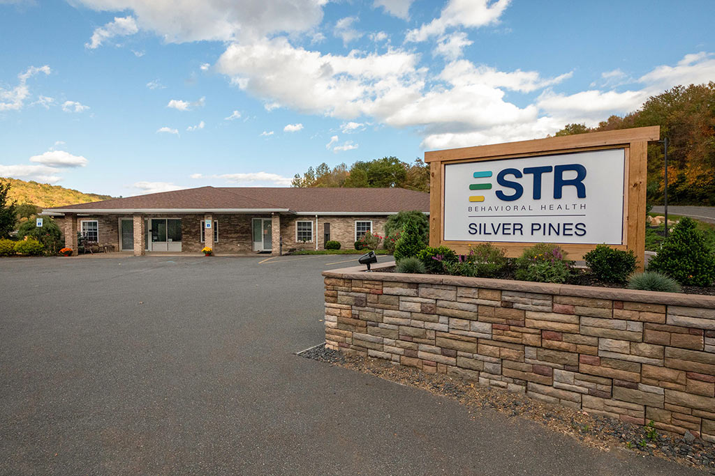 Facility exterior with driveway and welcome sign