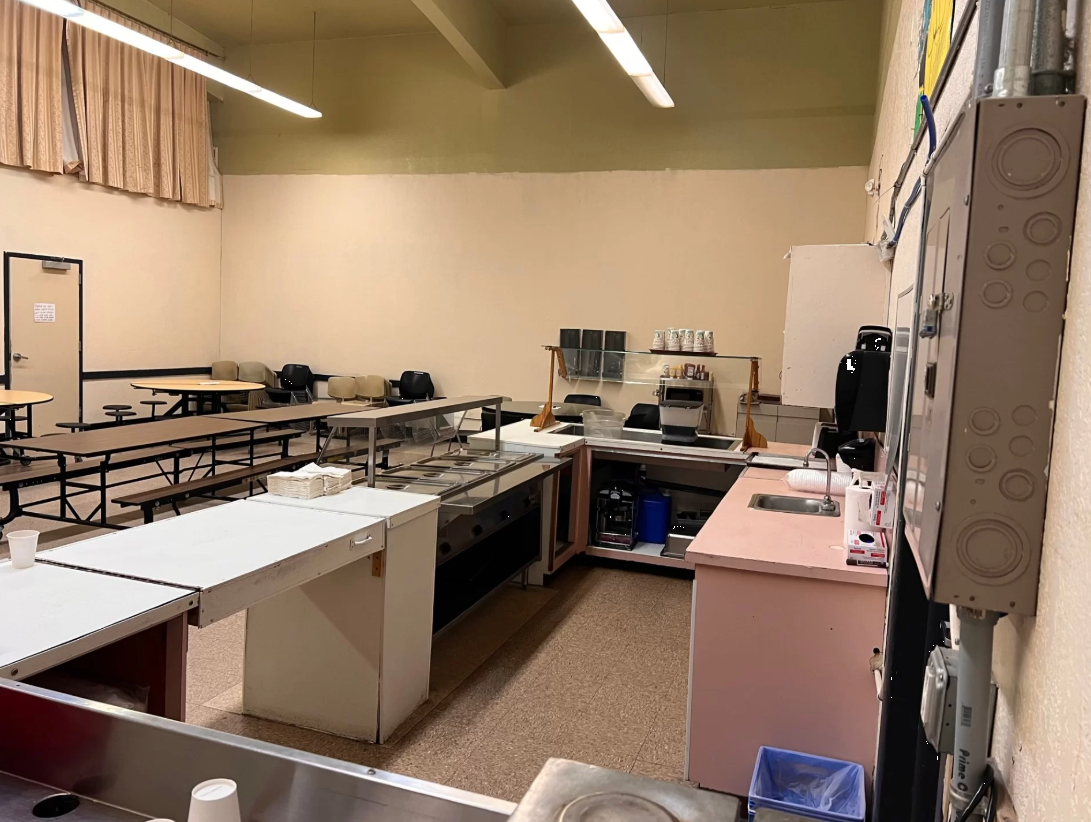 Cafeteria-style dining area with serving counter and tables