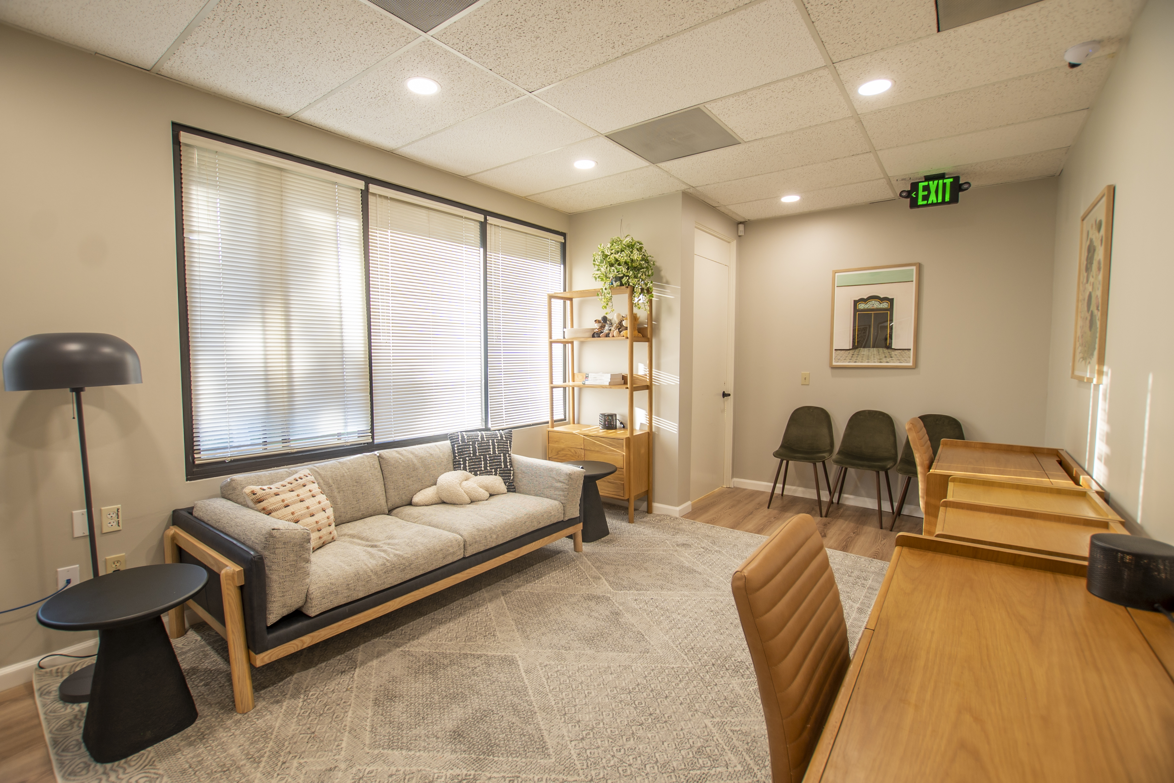 Cozy lounge with a modern gray sofa, desk, and warm lighting