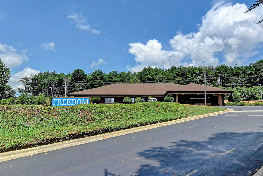 One-story building with hedges and Freedom sign