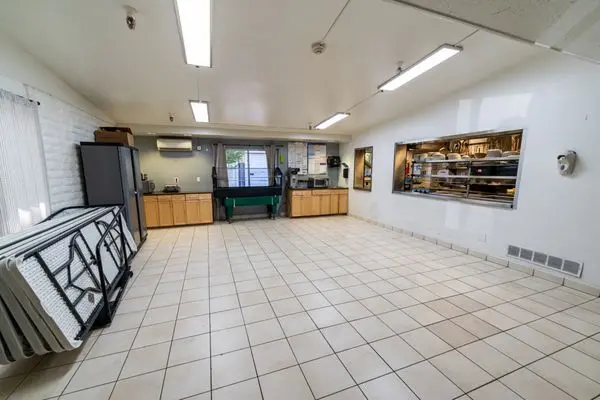 Large dining space with kitchen window and tiled floor